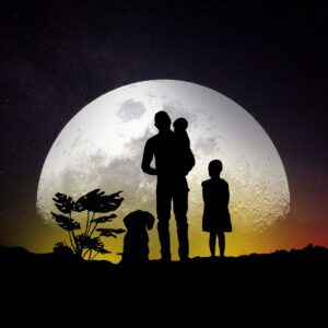 un homme avec un enfant dans les bras et un autre à côté avec un chien. La Lune est immense derrière eux. Cela illustre la numérologie guidance parentale